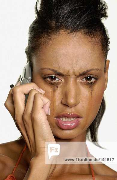 Crying woman using cellular telephone