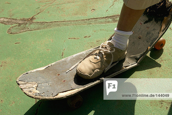 Fuß auf gebrochenem Skateboard