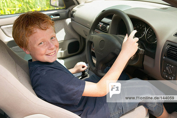 Lächelnder Junge am Steuer eines Autos