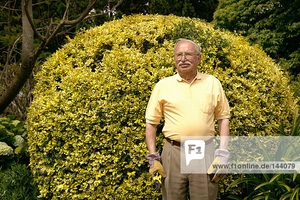 Älterer Mann im Garten stehend