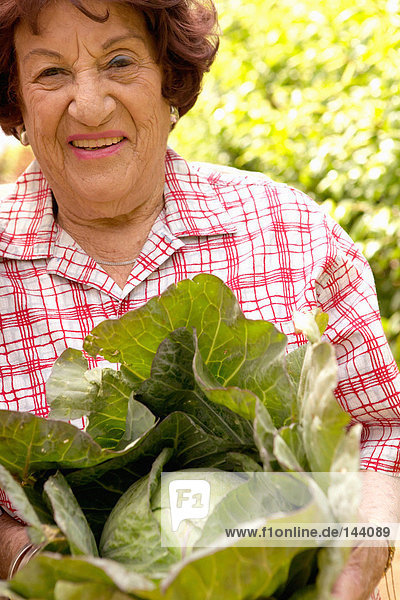 Porträt einer älteren Frau mit einem Kohlkopf