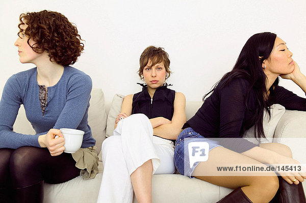 Frauen sitzen Rücken an Rücken auf dem Sofa