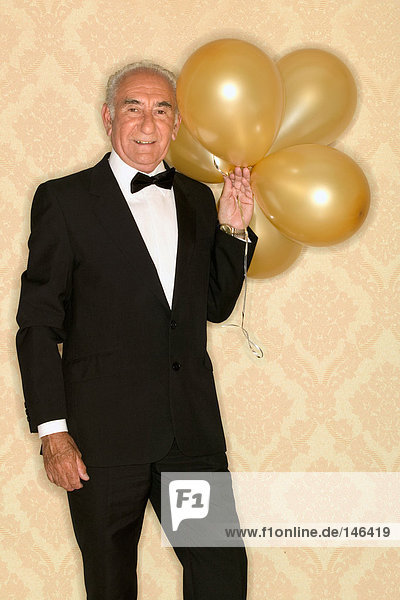 Älterer Mann mit einem Haufen Ballons.