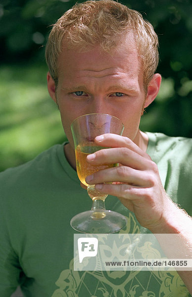 Junge Männer trinken aus Glas