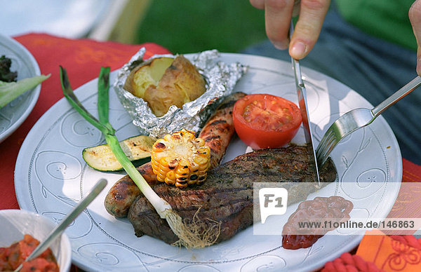 Cutting steak on plate.