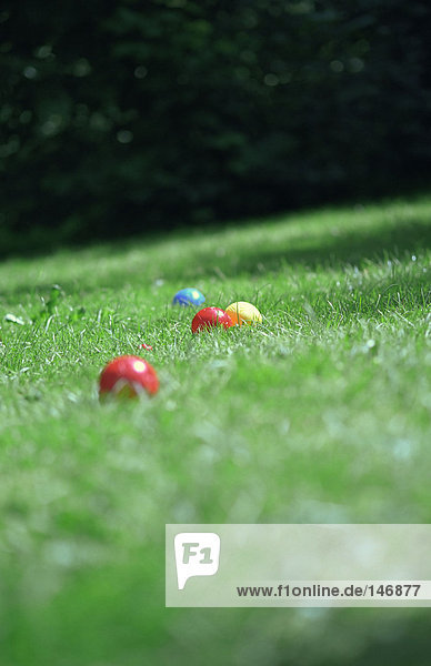 Coloured plastic balls in grass.