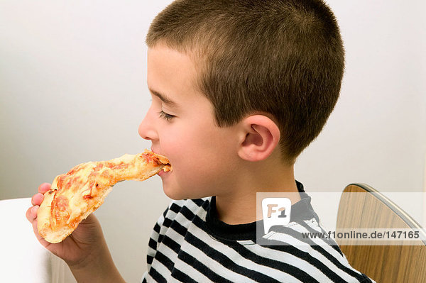 Boy eating a slice of pizza