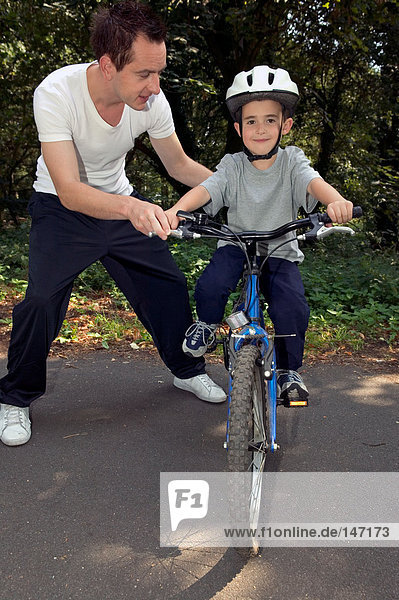 A father helping his son ride a bike