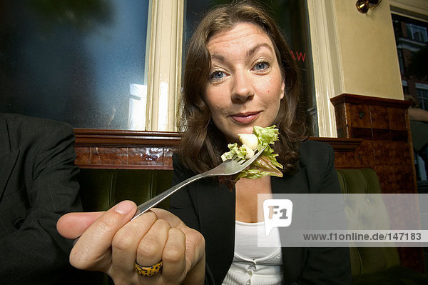 A businesswoman having a salad in a pub