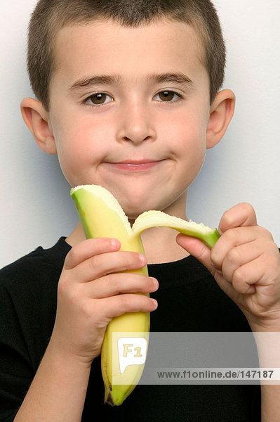 Boy peeling a banana