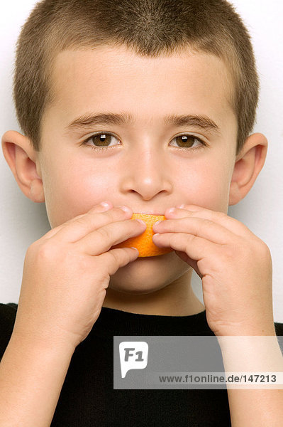 Boy eating an orange segment