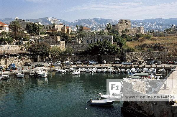 Boats at a marina with a town in the background  Byblos  Lebanon