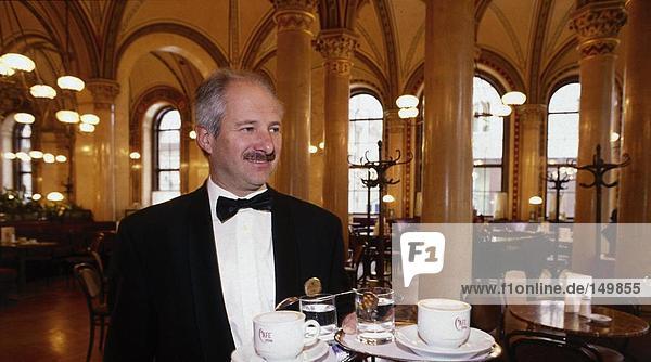 Waiter holding serving tray in cafe  Vienna  Austria