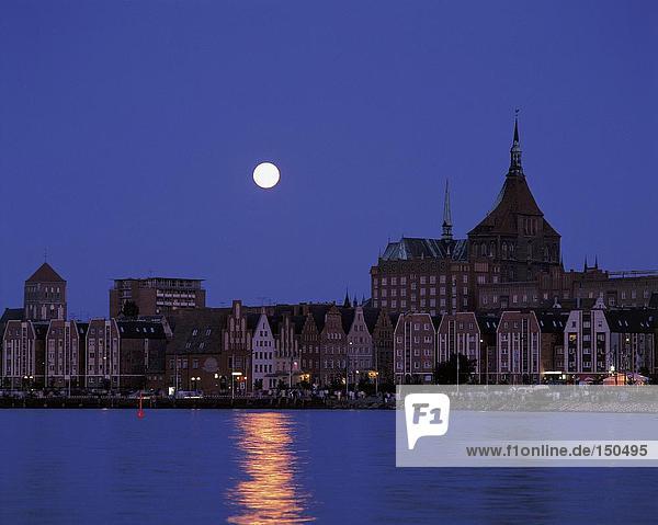 Moon over city at waterfront  Rostock  Germany