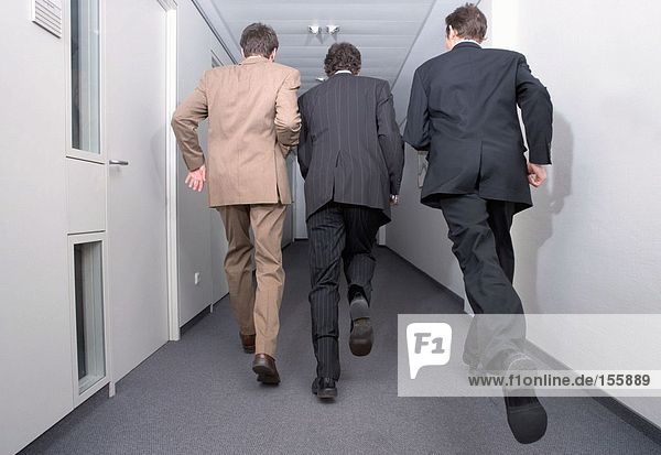 Businessmen running in corridor