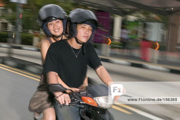 Junges asiatisches Paar auf Moped