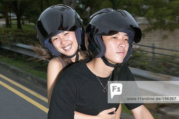 Junges asiatisches Paar auf Moped