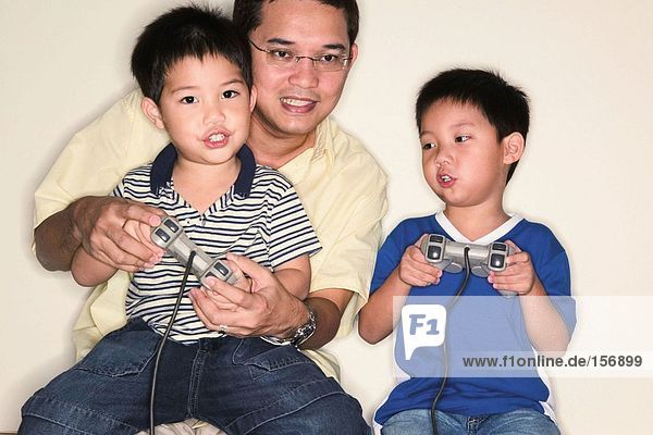 Vater und Söhne spielen Videospiel
