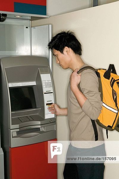 Mann mit einem Geldautomaten