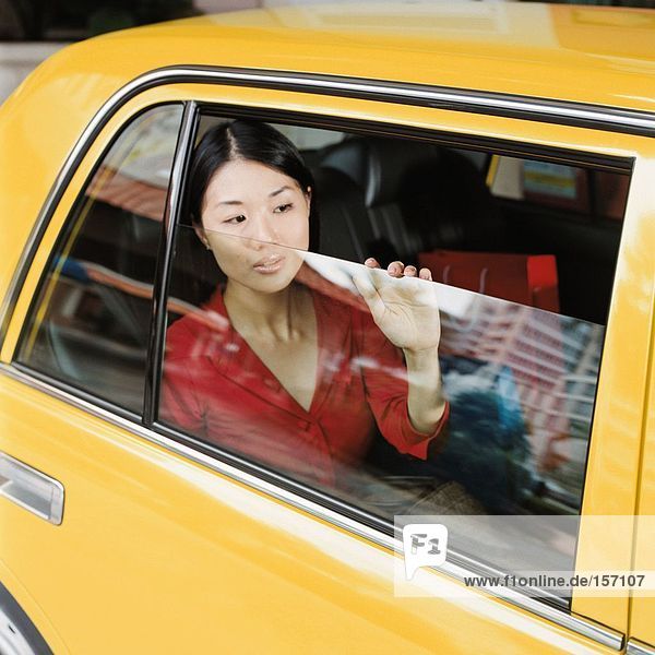 Frau schaut aus dem Taxi-Fenster