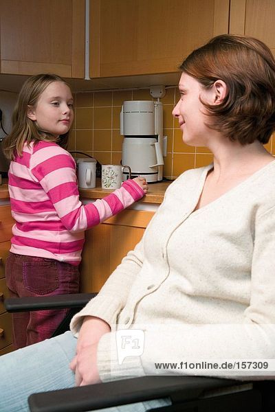 Disabled mother and daughter in kitchen