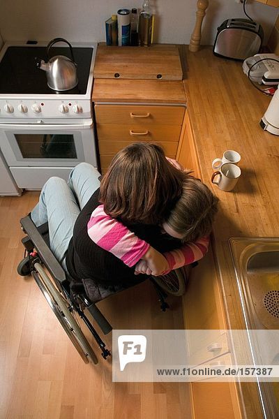 Behinderte Mutter und Tochter umarmend