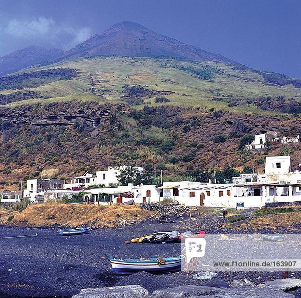 Two men standing on beach with mountain in background  Mt. Stromboli  Aeolian Islands  Sicily  Italy