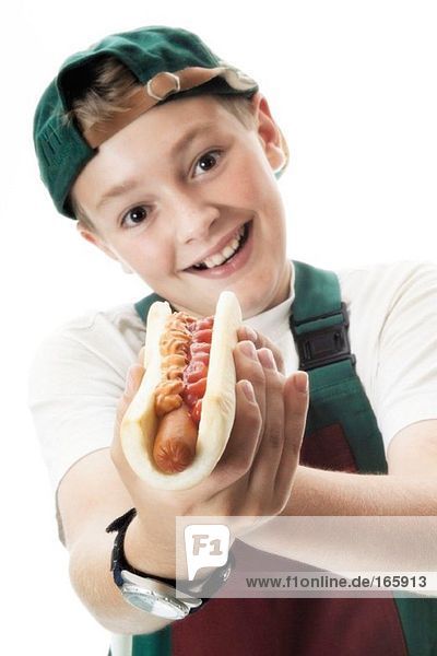 Junge hält Hot Dog in der Hand  lächelnd