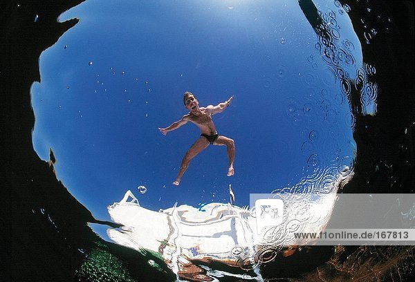 Travel. Egypt. Red Sea. Man diving into swimming pool. View from under the water.