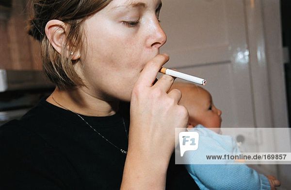 Woman smoking in kitchen