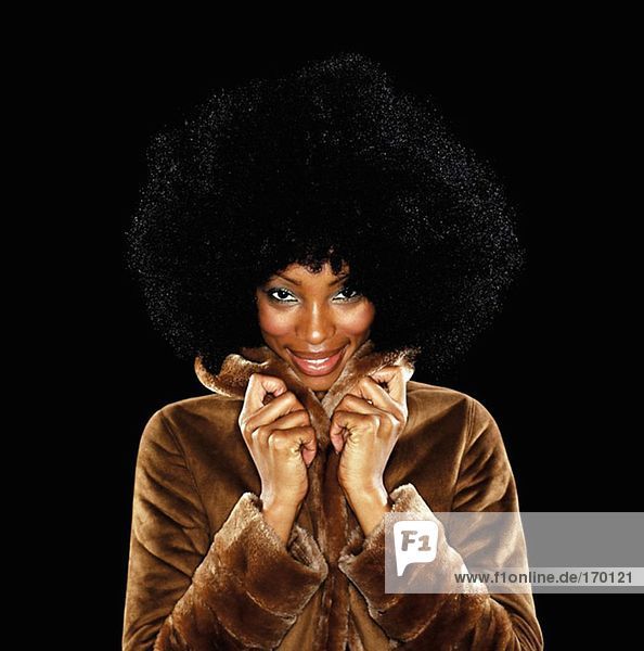 Junge Frau im Pelzmantel mit afro