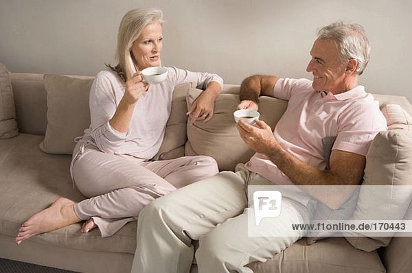 Couple on sofa drinking tea