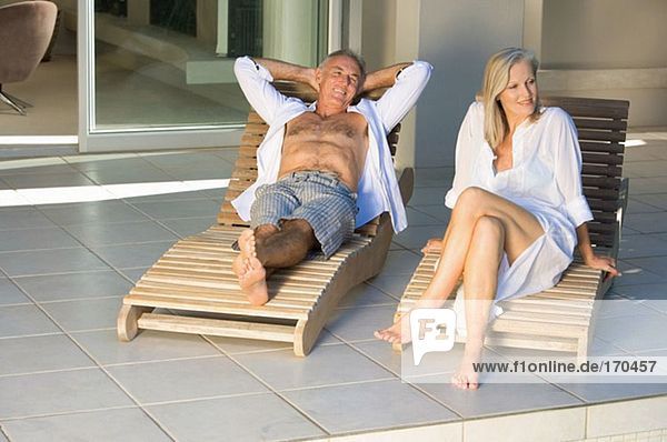 Mature couple in lounge chairs