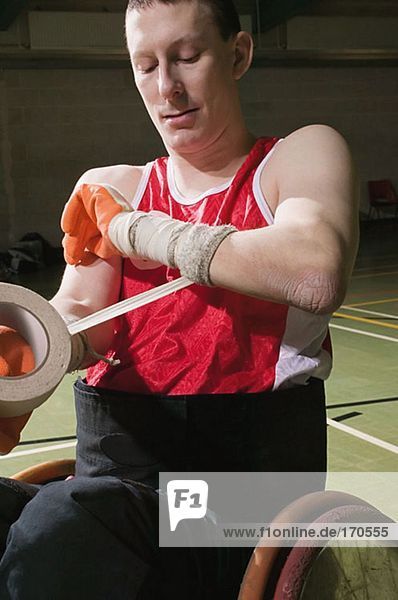 Quad-Rugbyspieler  der seinen Arm bandagiert.