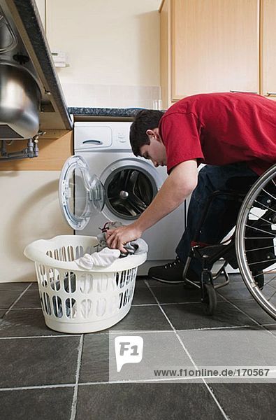 Behinderter Mann beim Wäschewaschen