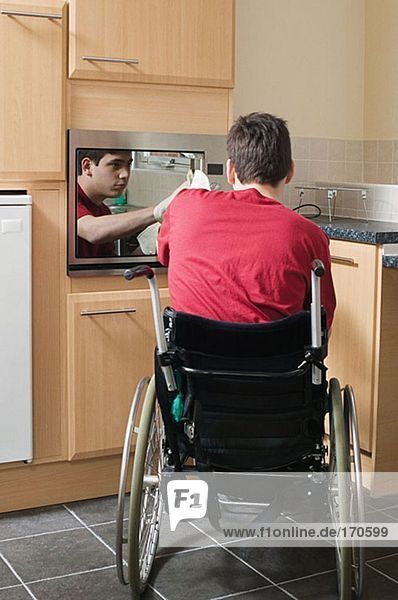 Behinderter Mann beim Öffnen des Ofens