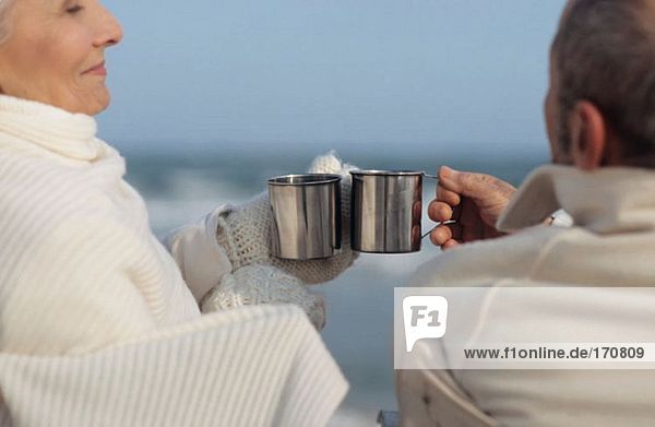 Seniorenpaar bei einem Drink am Strand
