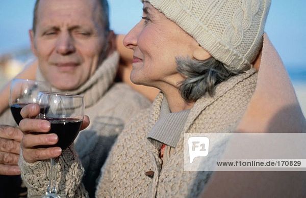 Seniorenpaar trinkt Wein in Decke