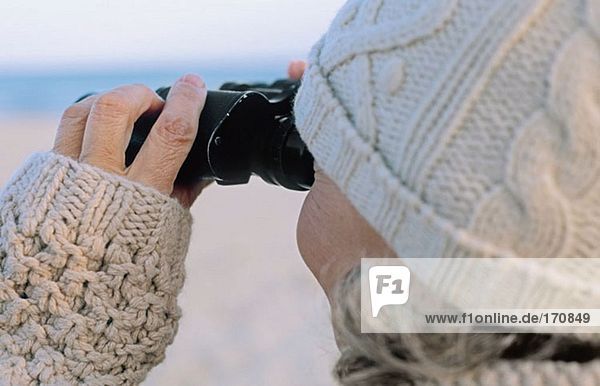 Rückansicht der Seniorin mit dem Fernglas