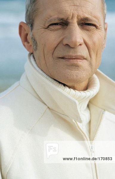 Senior Mann am Strand mit Blick auf die Kamera