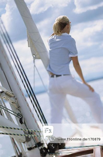 Rear view of woman on boat looking out to sea