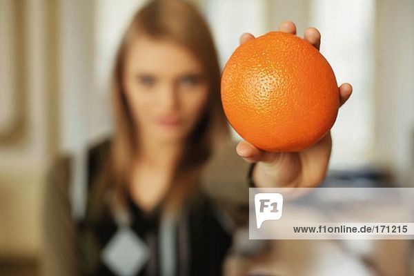 Woman holding out an orange