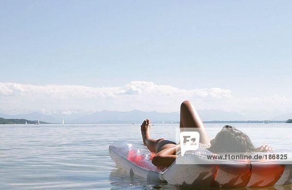 Frau auf Luftmatratze vorne liegend  Starnberger See