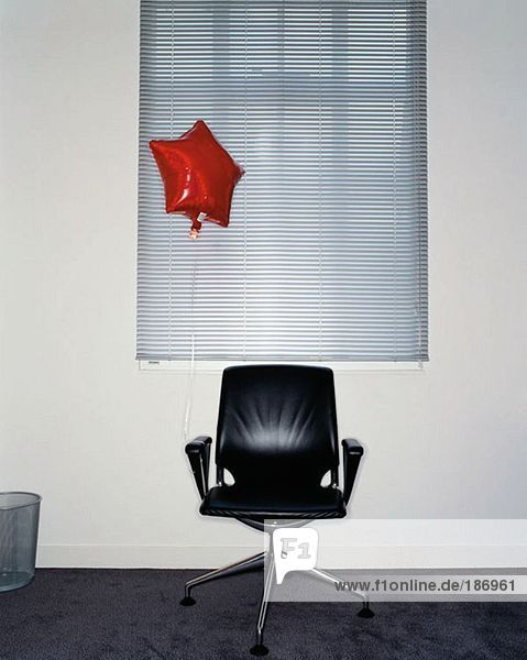 Ballon am Bürostuhl befestigt