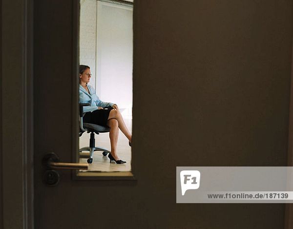 Geschäftsfrau sitzt allein im Büro