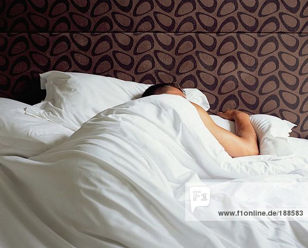 Mann schläft in einem Bett