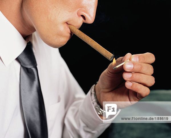 Geschäftsmann beim Anzünden einer Zigarre