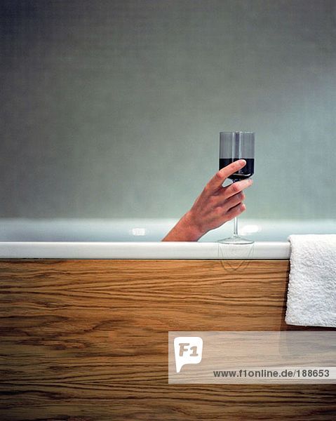 Frau mit einem Glas Wein im Bad
