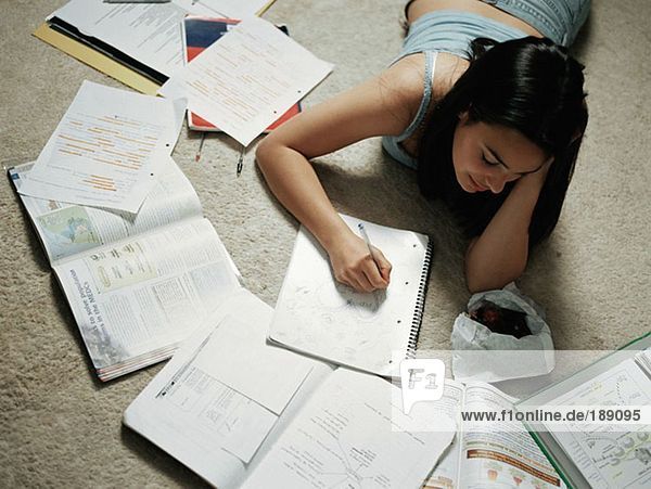 Girl doing homework on floor