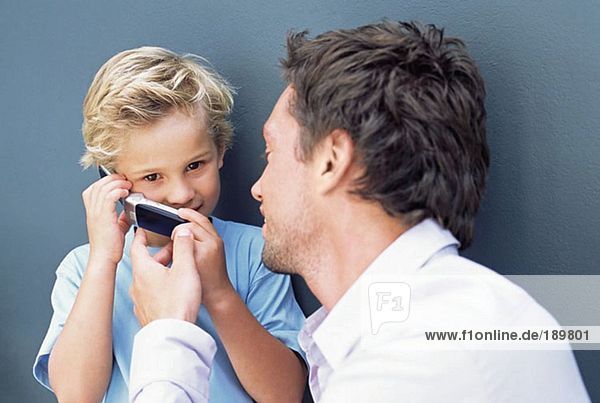 Father letting son use mobile phone
